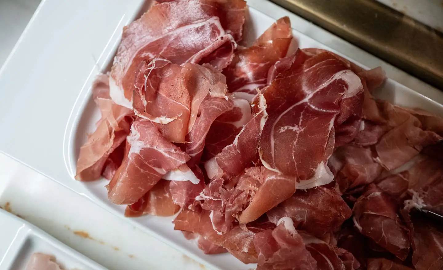 Mangi prosciutto cotto o crudo pensando sia più sano? Ecco la verità sorprendente sulla loro lavorazione
